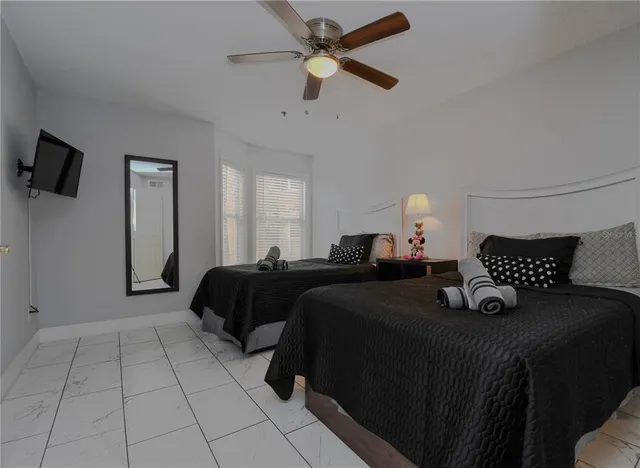 a bedroom with a bed and a ceiling fan