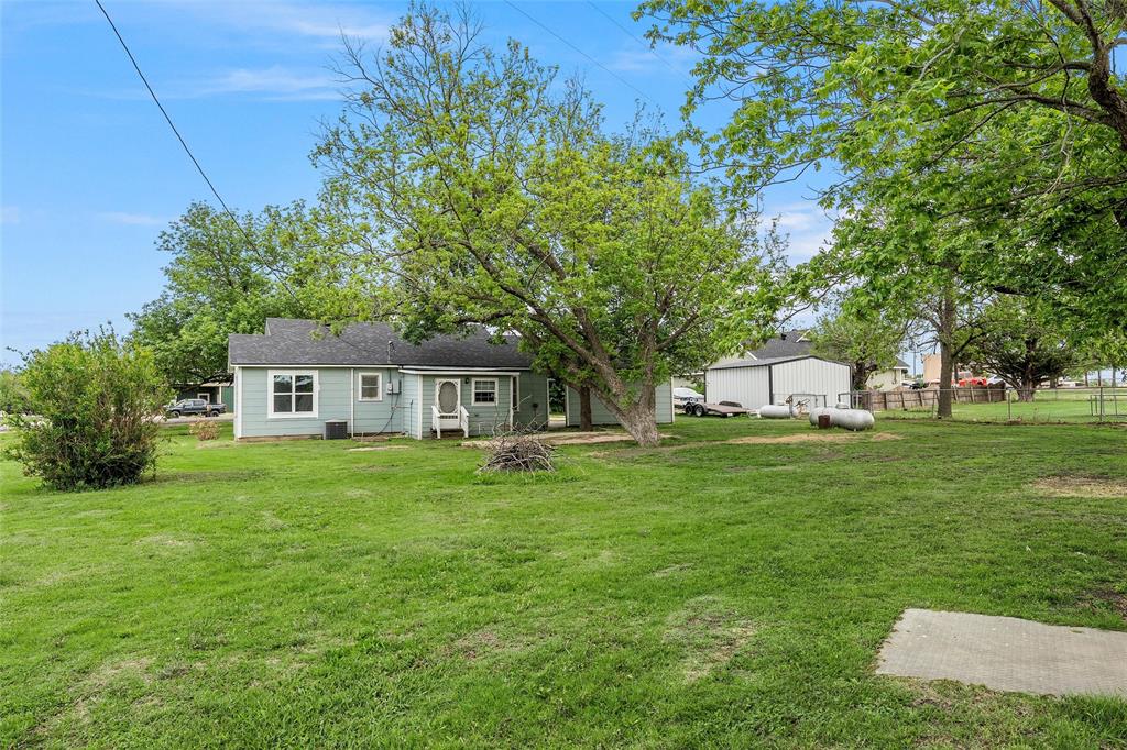 731 Highway 320 Lott, TX 76656 - Photo 14 of 16 a front view of a house with a garden and trees
