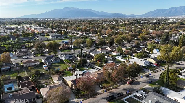 an aerial view of a city with lots of residential buildings and mountain view in back