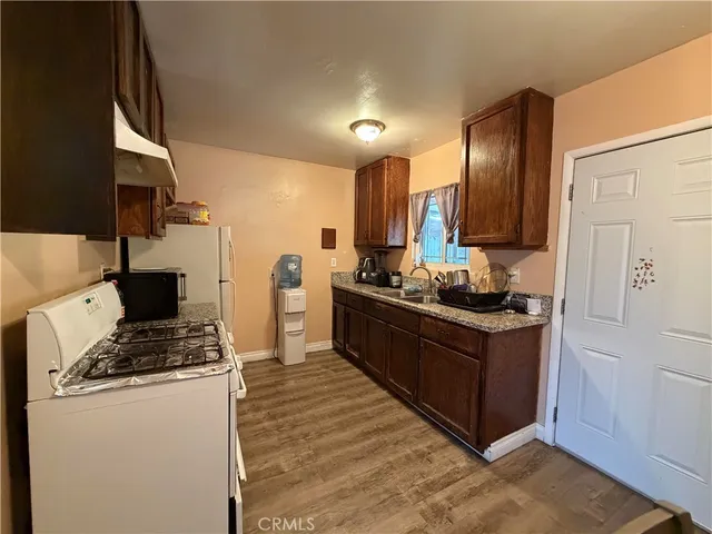 a kitchen with kitchen island granite countertop a sink stove and refrigerator