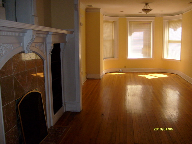 4810 South Prairie Avenue, Unit 2N Chicago, IL 60615 - Photo 3 of 15 a view of empty room with wooden floor and fan