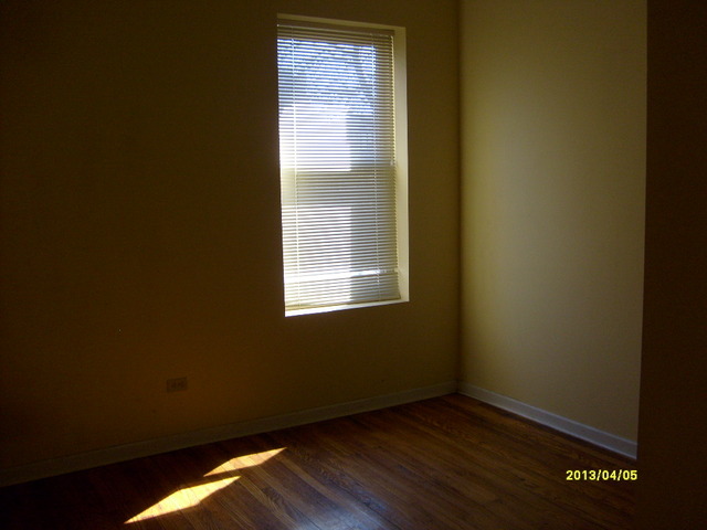 4810 South Prairie Avenue, Unit 2N Chicago, IL 60615 - Photo 5 of 15 a view of an empty room with wooden floor and a window