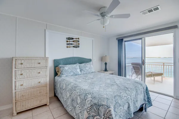 a bedroom with a large bed and ceiling fan