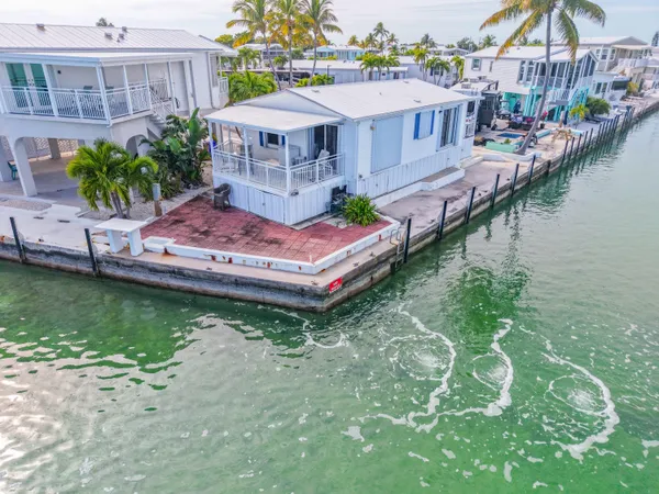 a front view of a house with a garden and trees