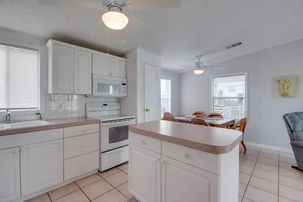 a kitchen with a sink stools a counter space and cabinets
