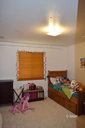 1117 South McCall Street Ridgecrest, CA 93555 - Photo 7 of 11 a bed room with furniture and a gate