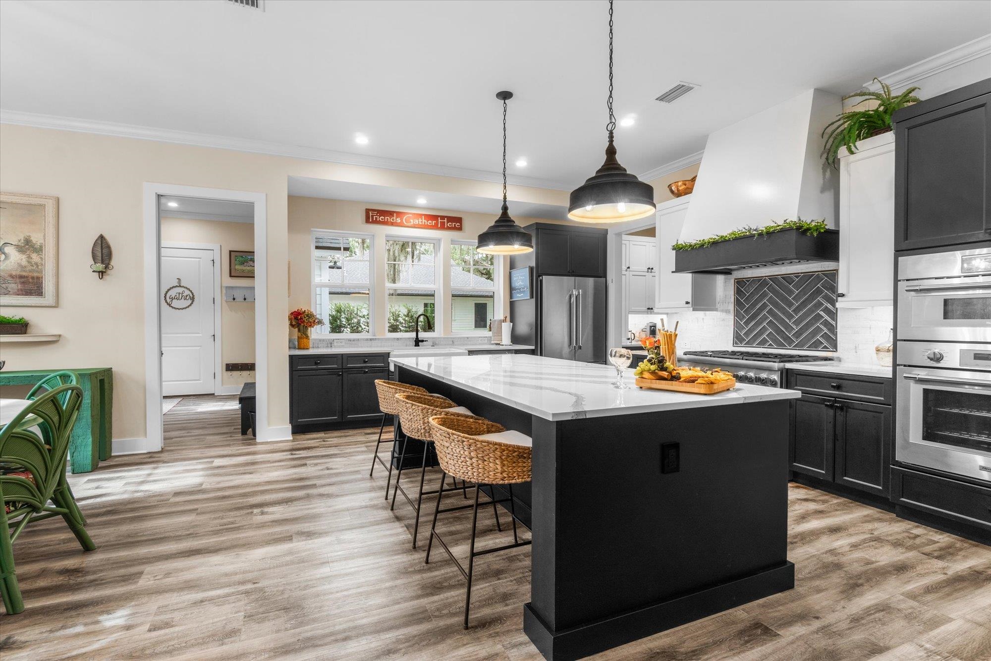 29318 Grandview Manor Yulee, FL 32097 - Photo 16 of 68 Kitchen featuring tasteful backsplash, premium range hood, dark cabinetry, a kitchen bar, and ornamental molding