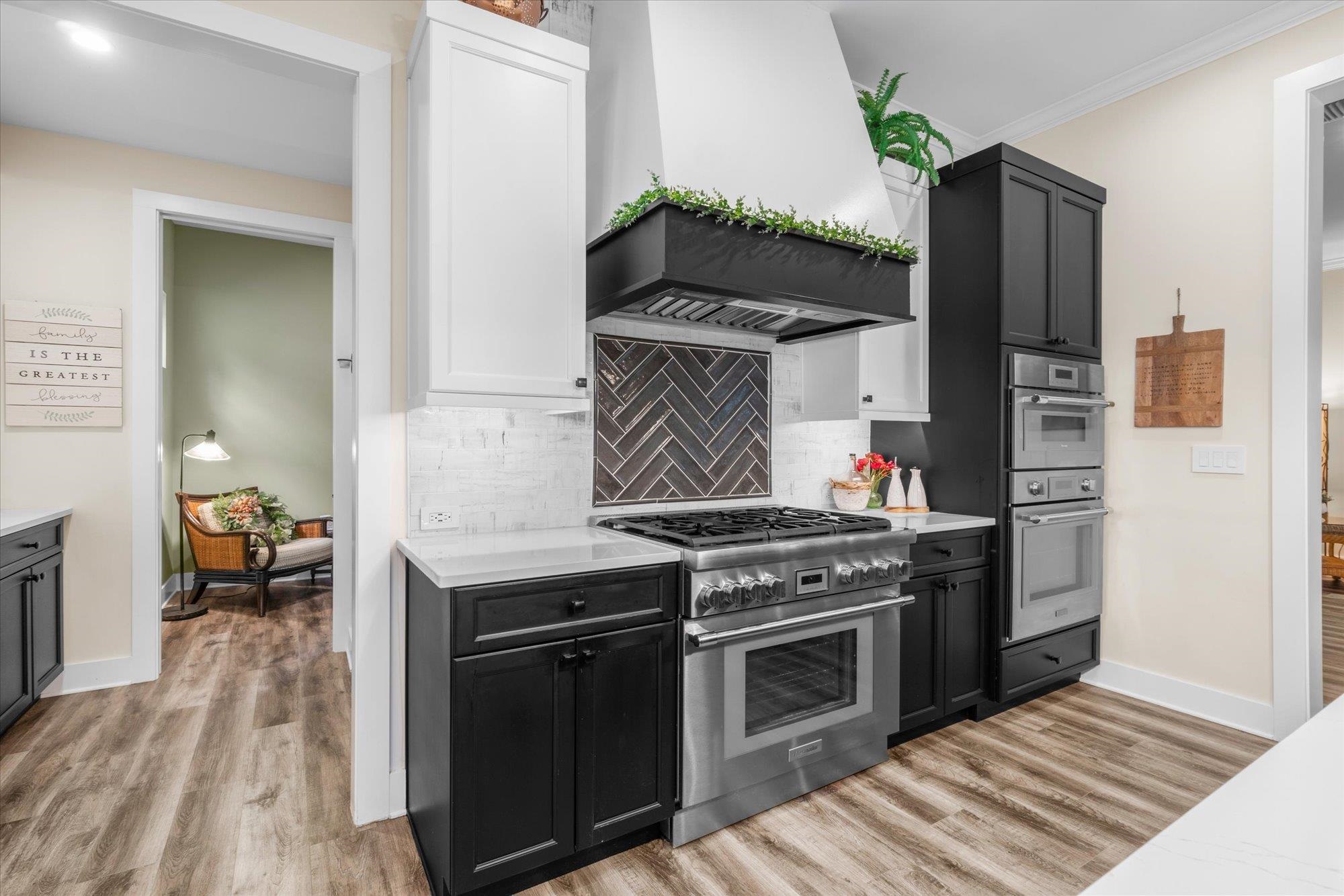 29318 Grandview Manor Yulee, FL 32097 - Photo 19 of 68 Kitchen with dark cabinetry, stainless steel appliances, custom range hood, tasteful backsplash, and light wood finished floors