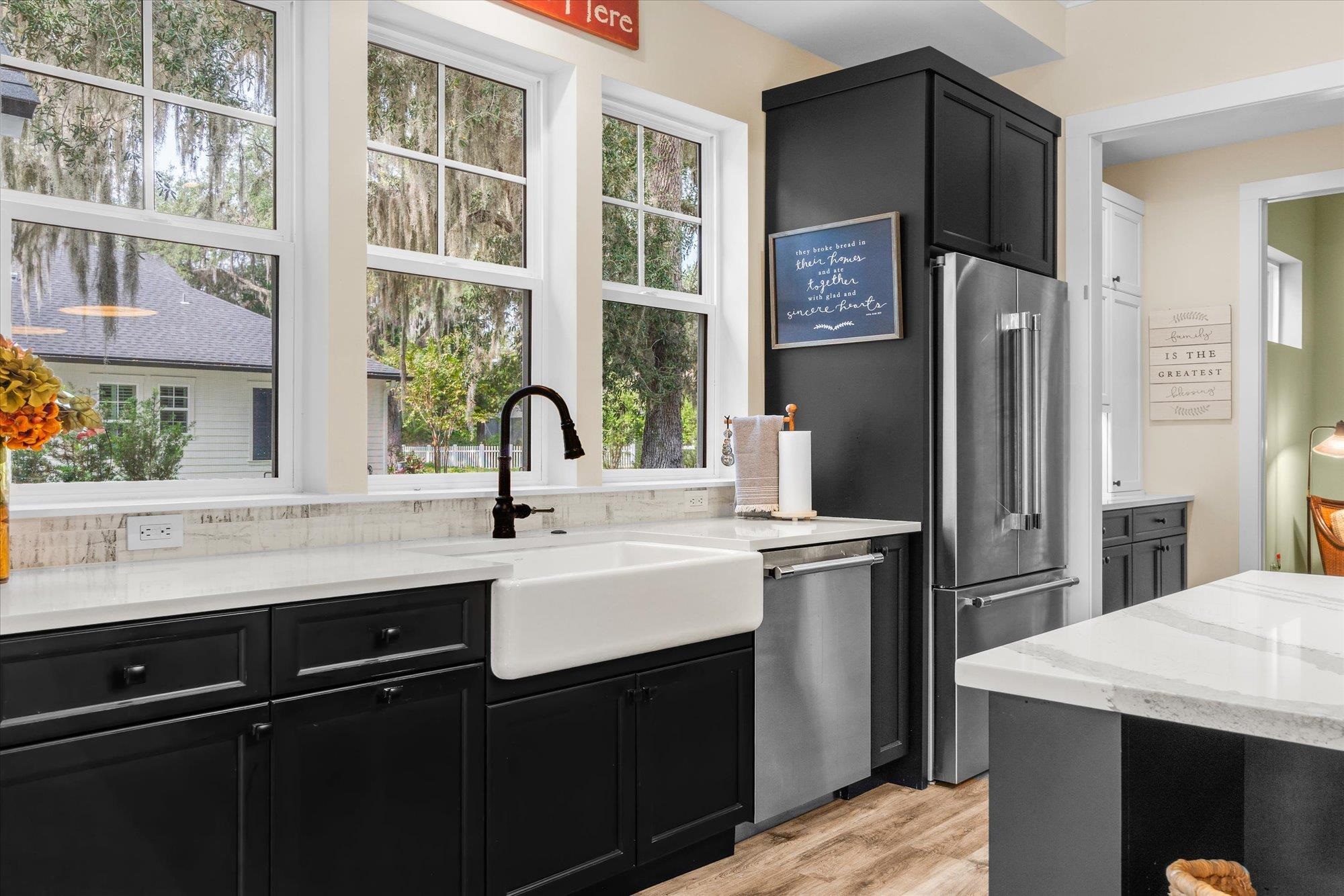29318 Grandview Manor Yulee, FL 32097 - Photo 21 of 68 Kitchen featuring dark cabinetry, light stone counters, stainless steel appliances, and light wood-type flooring