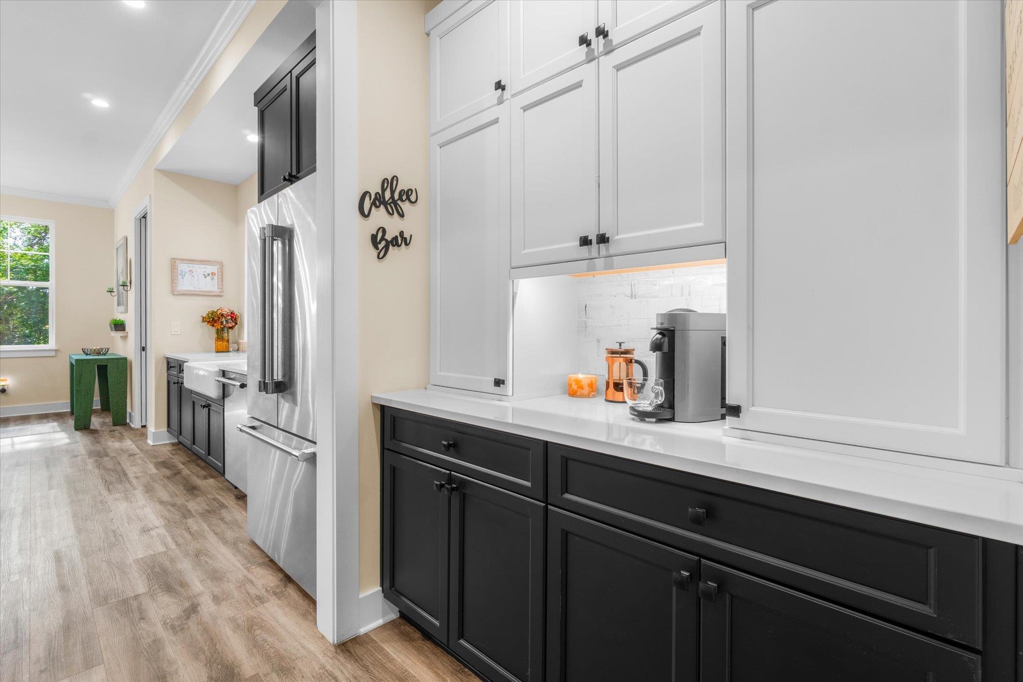 29318 Grandview Manor Yulee, FL 32097 - Photo 25 of 68 Kitchen featuring dark cabinetry, crown molding, light wood-style flooring, high quality fridge, and light stone countertops