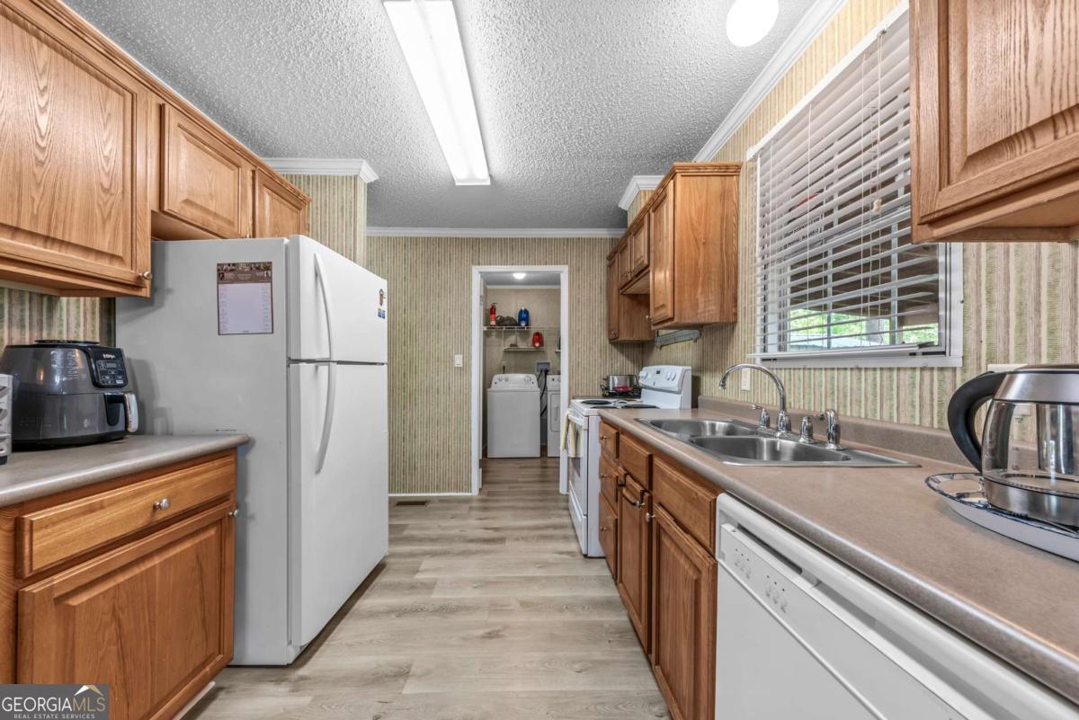 194 Phillips Road Eatonton, GA 31024 - Photo 11 of 57 a kitchen with a refrigerator a sink and dishwasher