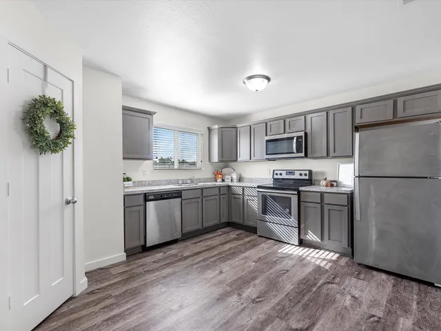 a kitchen with a refrigerator stove top oven and sink