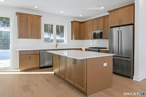 a kitchen with stainless steel appliances a refrigerator sink and microwave