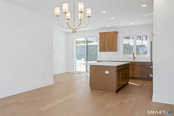 a living room with stainless steel appliances kitchen island granite countertop furniture and a large window
