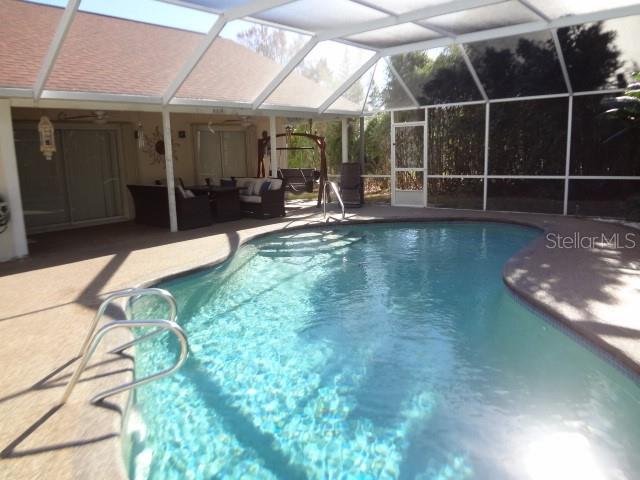 124 Foster Lane Palm Coast, FL 32137 - Photo 19 of 23 a view of a swimming pool with a patio and a yard