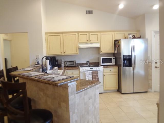 124 Foster Lane Palm Coast, FL 32137 - Photo 7 of 23 a kitchen with kitchen island a sink stove and refrigerator