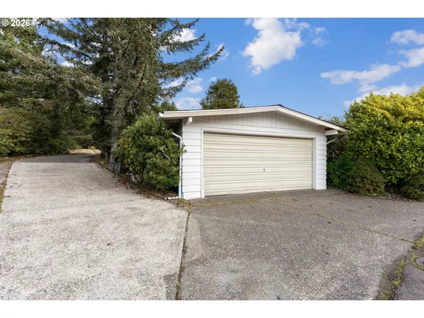 a view of backyard of house and garage