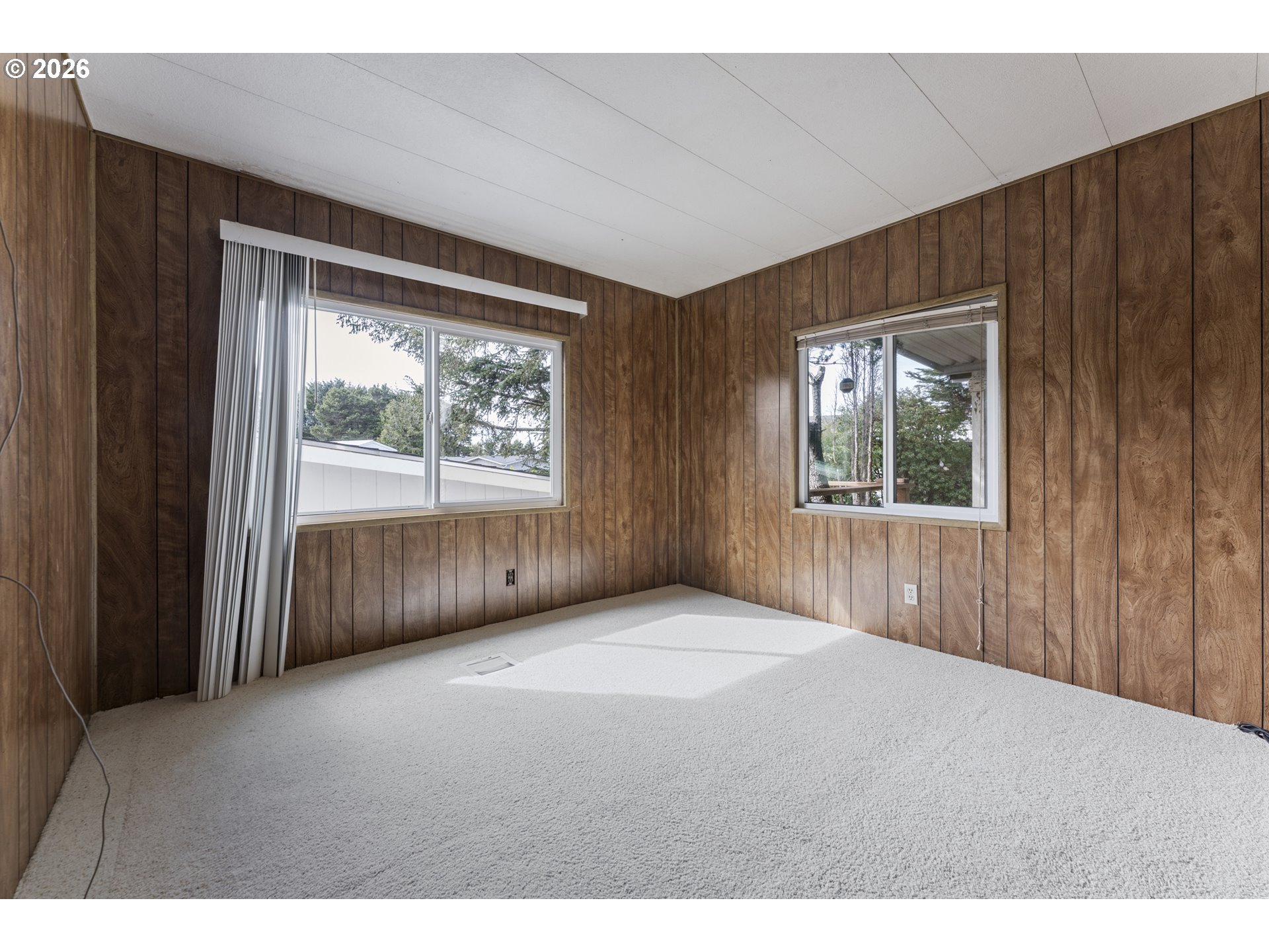 1600 Rhododendron Drive, Unit 415 Florence, OR 97439 - Photo 14 of 29 a view of an empty room with wooden floor and a window