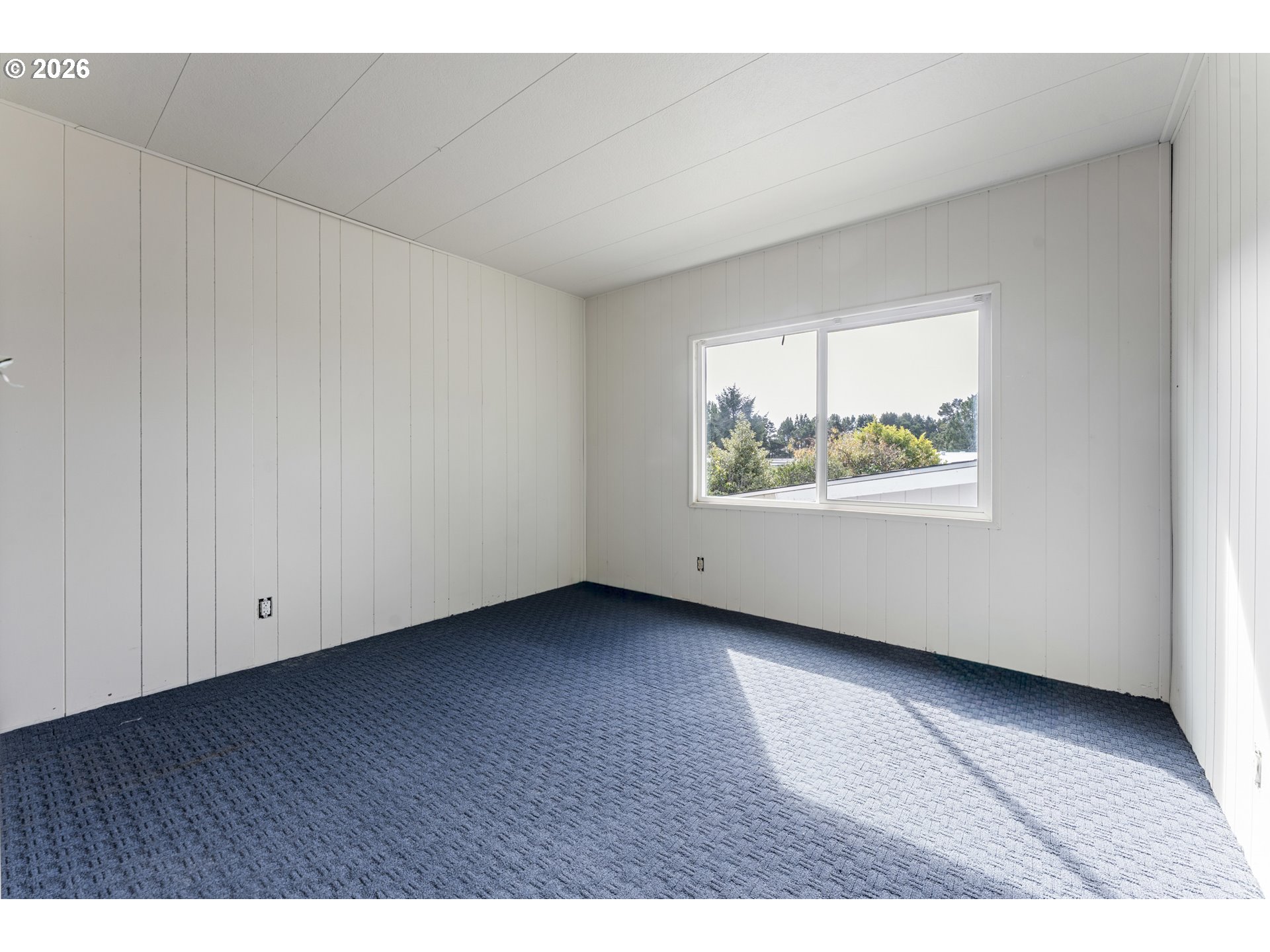 1600 Rhododendron Drive, Unit 415 Florence, OR 97439 - Photo 17 of 29 a view of an empty room with wooden floor and a window
