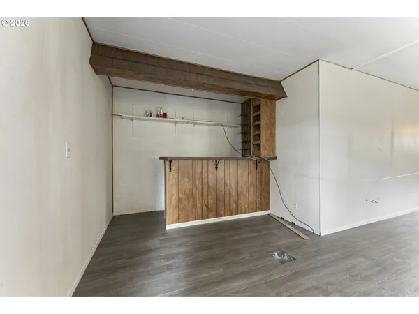 a view of an empty room with wooden floor and closet