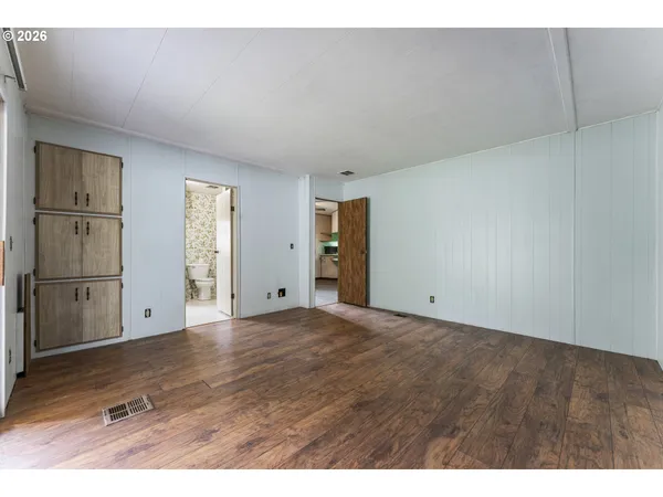 a view of an empty room with cabinet and entryway