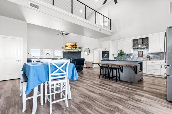 a kitchen with stainless steel appliances granite countertop a table chairs stove a sink and dishwasher