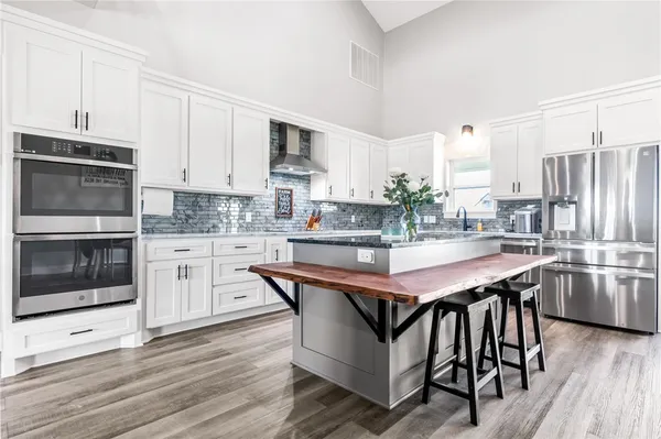 a kitchen with stainless steel appliances granite countertop a stove a sink dishwasher a microwave oven with cabinets and wooden floor