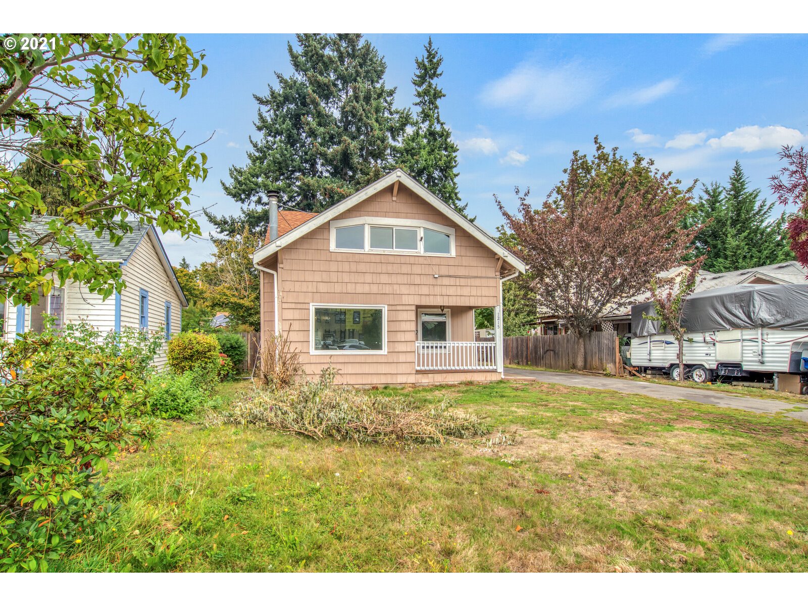1215 2nd Street Northwest Salem, OR 97304 - Photo 3 of 32 a front view of a house with a garden and trees