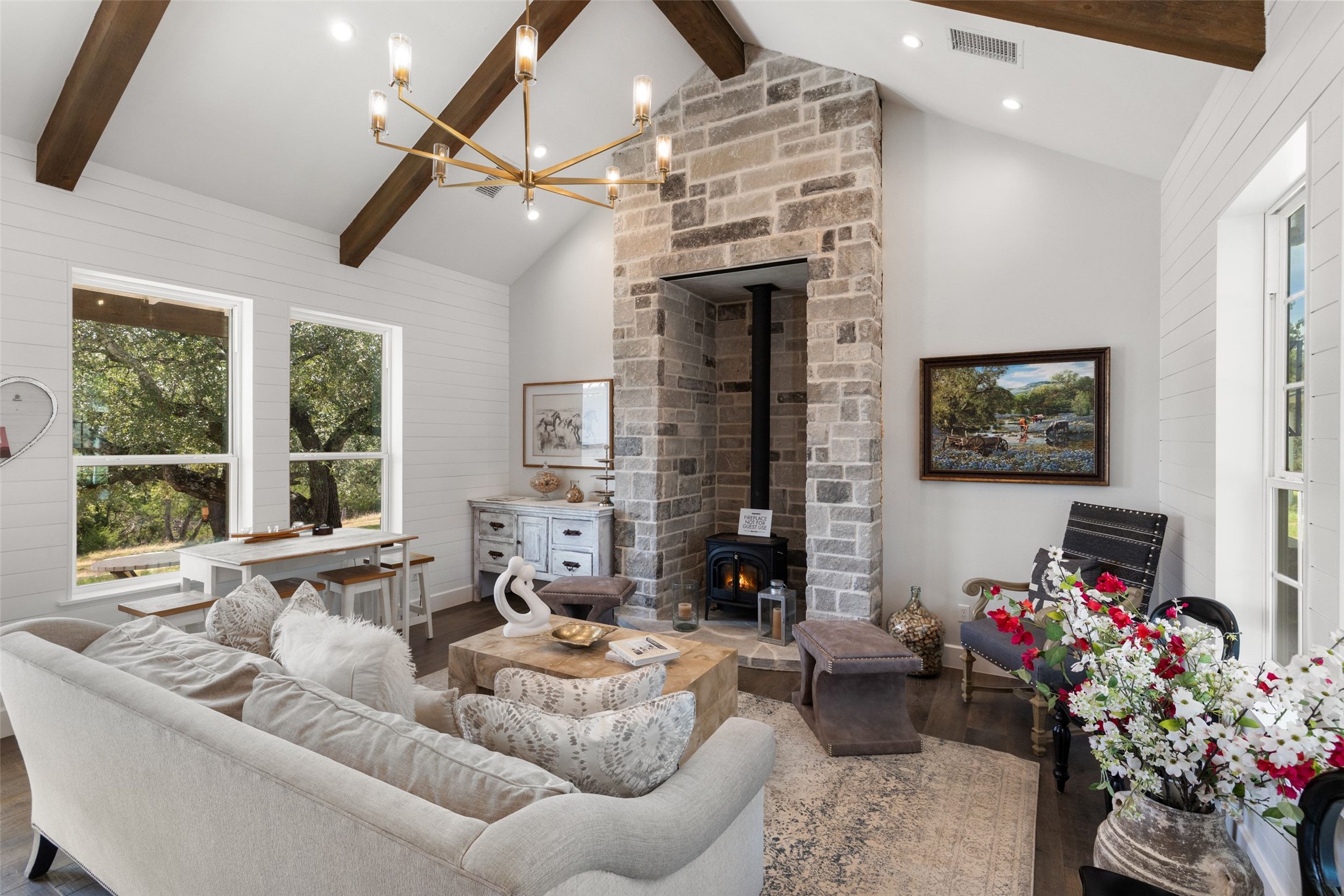 810 Kothmann Road Dripping Springs, TX 78620 - Photo 12 of 40 Exposed ceiling beams and a floor-to-ceiling stone fireplace anchor this inviting living space.