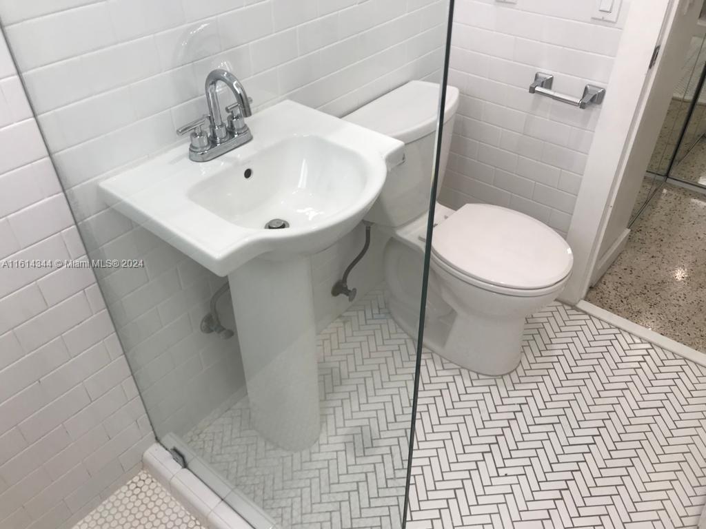 Santa Clara Miami, FL 33127 - Photo 8 of 11 a white toilet sitting next to a bathroom sink