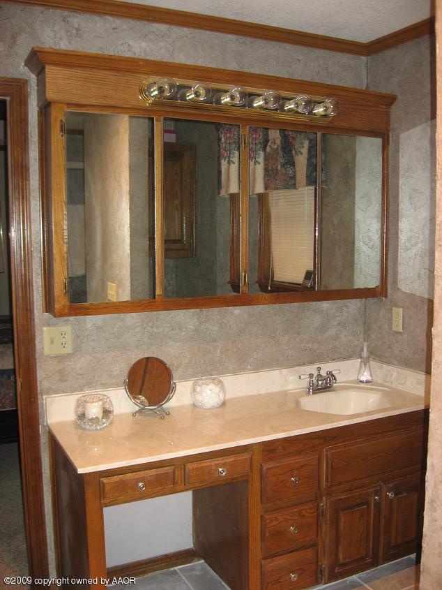 8308 Ranier Drive Amarillo, TX 79110 - Photo 14 of 16 a bathroom with a sink and a mirror