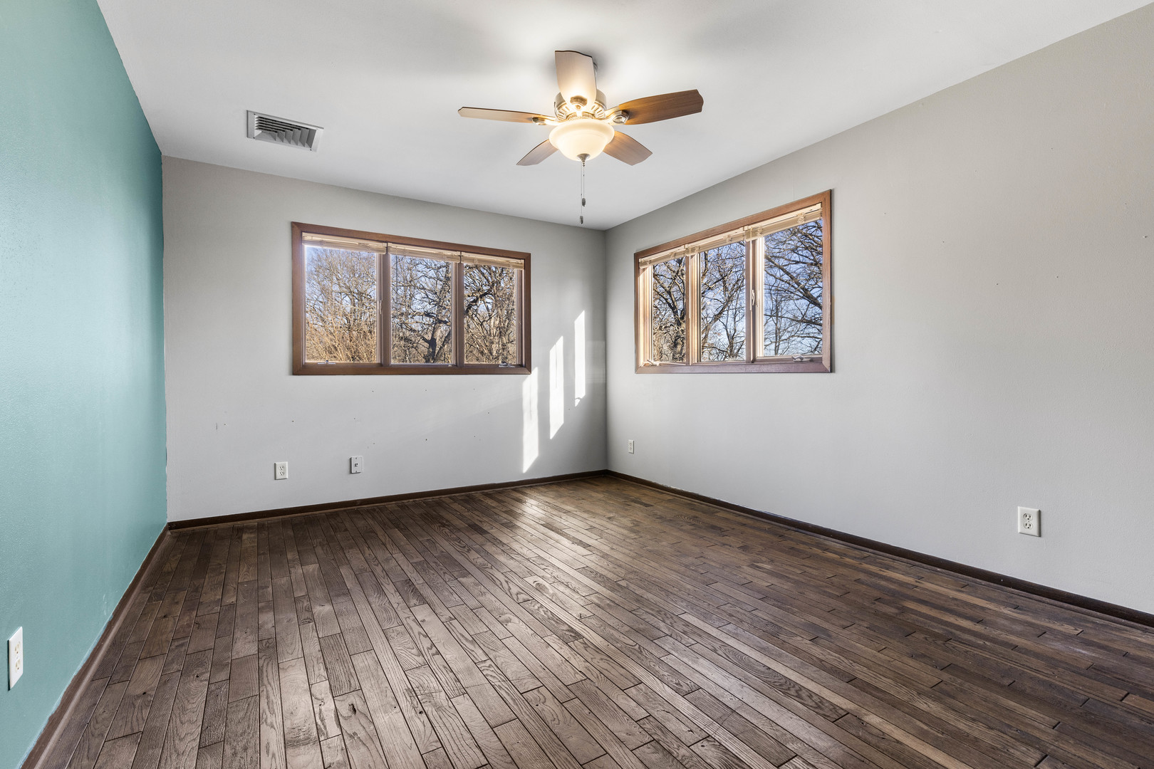 15291 Beaverton Road Poplar Grove, IL 61065 - Photo 23 of 37 an empty room with wooden floor chandelier fan and windows