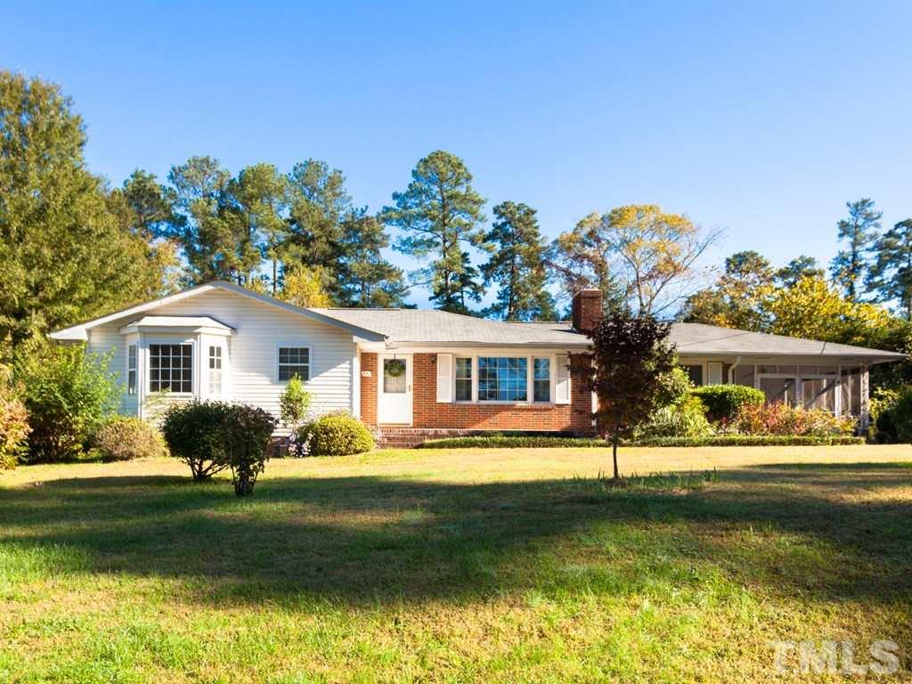 331 Golf Course Drive Raleigh, NC 27610 - Photo 1 of 25 a front view of a house with a garden and trees