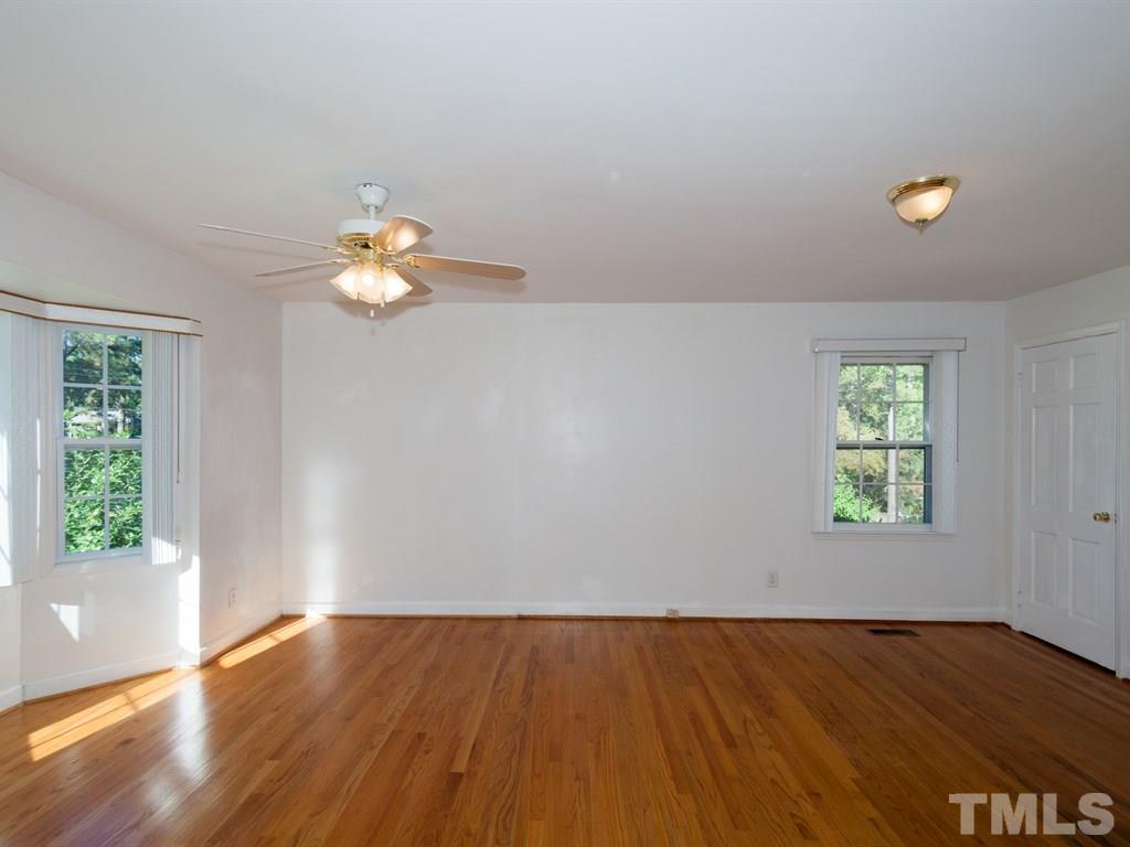 331 Golf Course Drive Raleigh, NC 27610 - Photo 11 of 25 an empty room with wooden floor and windows