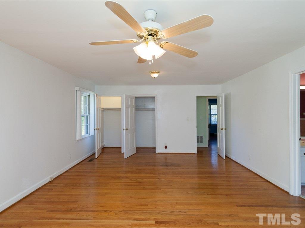 331 Golf Course Drive Raleigh, NC 27610 - Photo 14 of 25 a view of an empty room with wooden floor and a ceiling fan