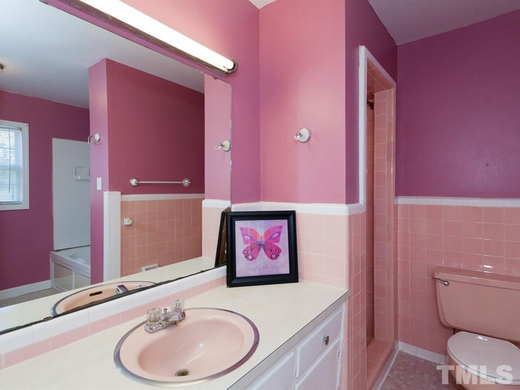 331 Golf Course Drive Raleigh, NC 27610 - Photo 16 of 25 a bathroom with a granite countertop sink and a mirror