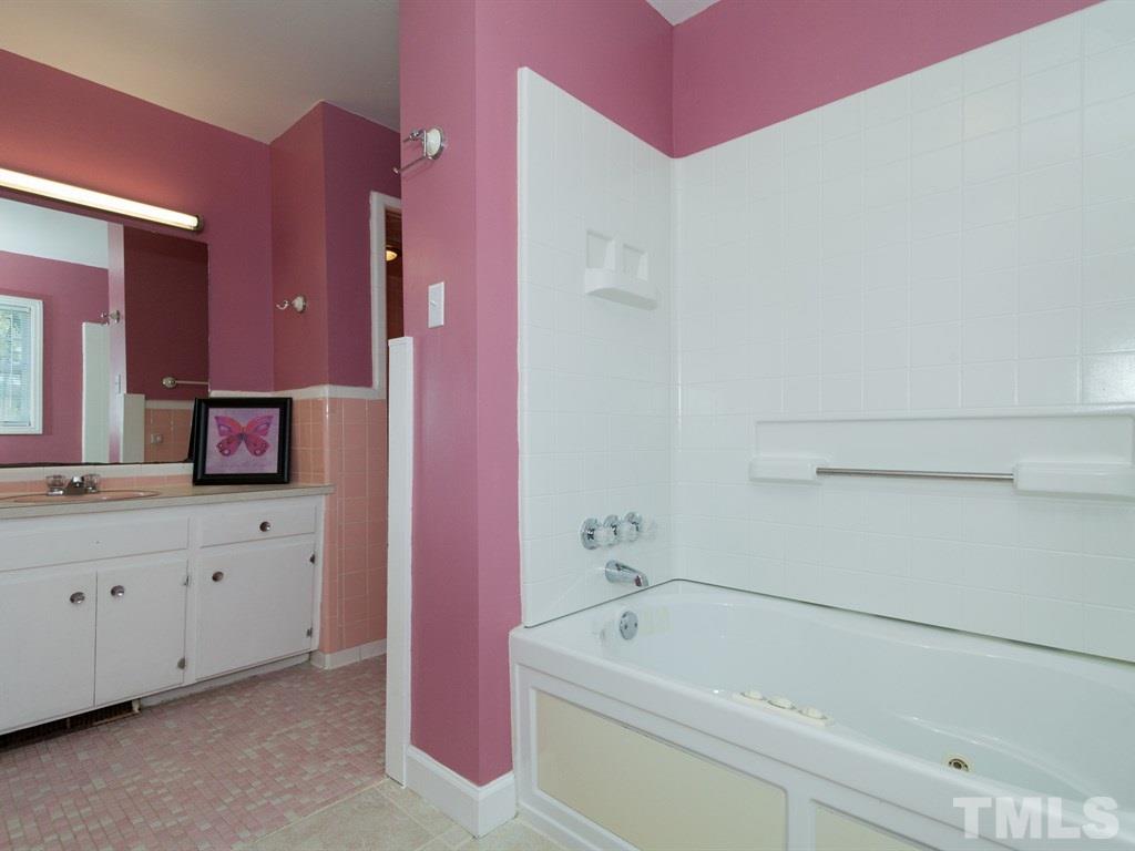 331 Golf Course Drive Raleigh, NC 27610 - Photo 17 of 25 a bathroom with a tub a sink and mirror