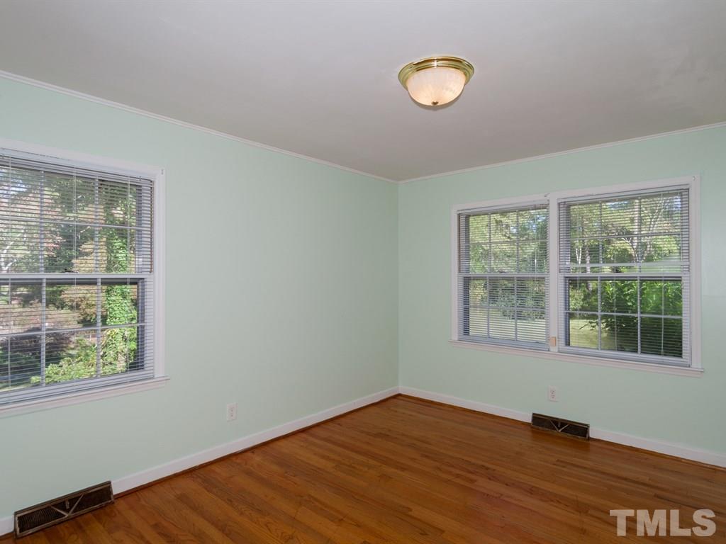 331 Golf Course Drive Raleigh, NC 27610 - Photo 18 of 25 a view of an empty room with wooden floor and a window