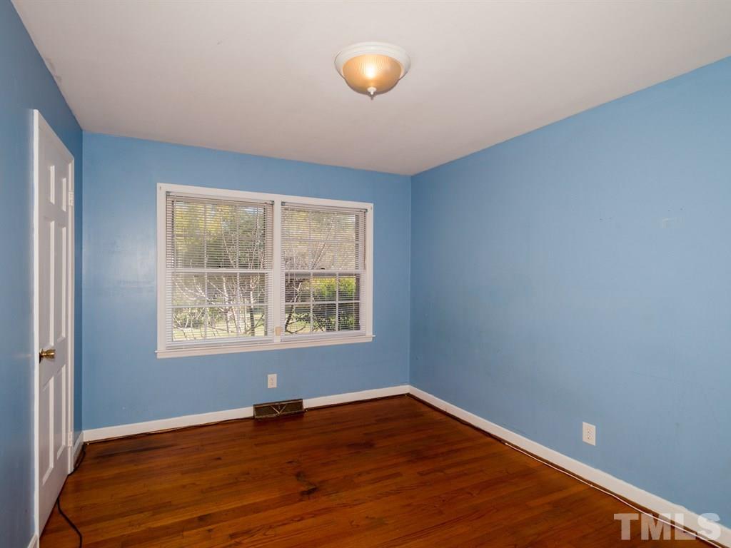 331 Golf Course Drive Raleigh, NC 27610 - Photo 19 of 25 a view of an empty room with wooden floor and a window
