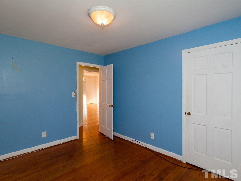 331 Golf Course Drive Raleigh, NC 27610 - Photo 20 of 25 an empty room with wooden floor and windows
