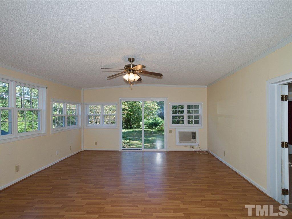 331 Golf Course Drive Raleigh, NC 27610 - Photo 9 of 25 an empty room with wooden floor fan and windows