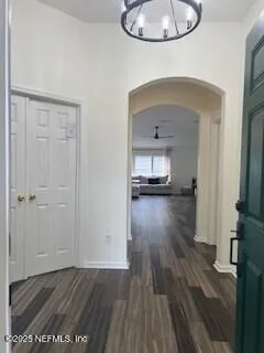 a view of a hallway view with wooden floor and a living room