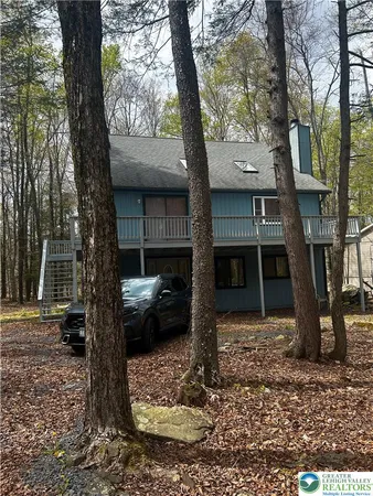 a front view of a house with a tree