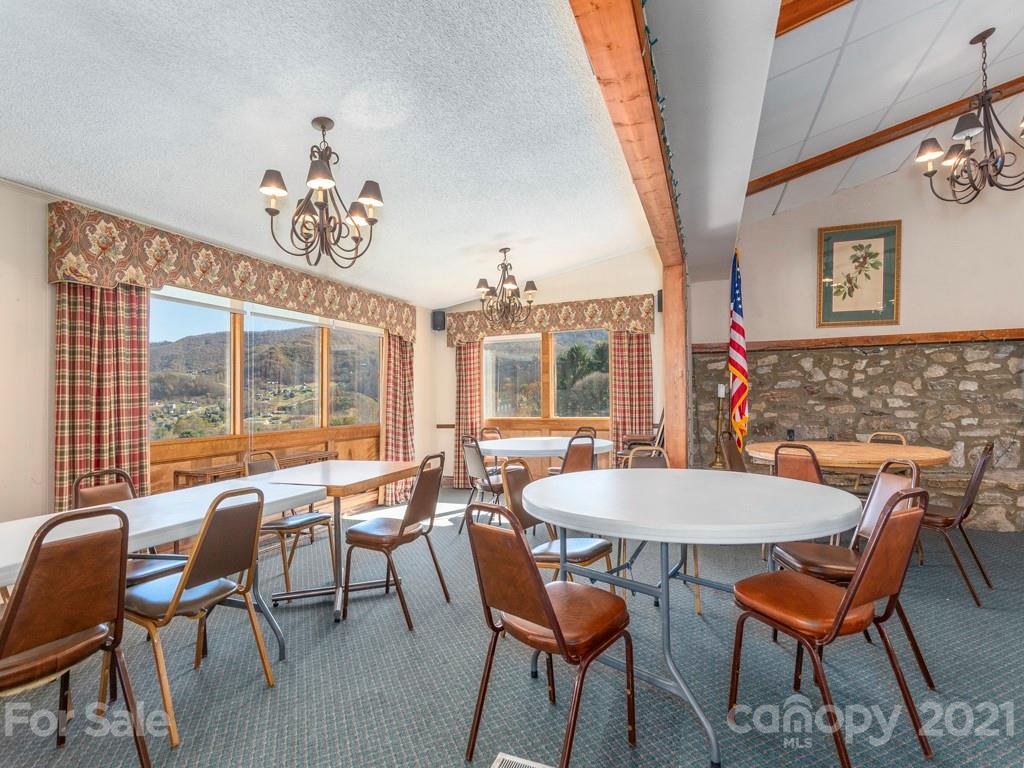 566 Walker Road Waynesville, NC 28786 - Photo 7 of 28 a dining room with furniture a chandelier and wooden floor