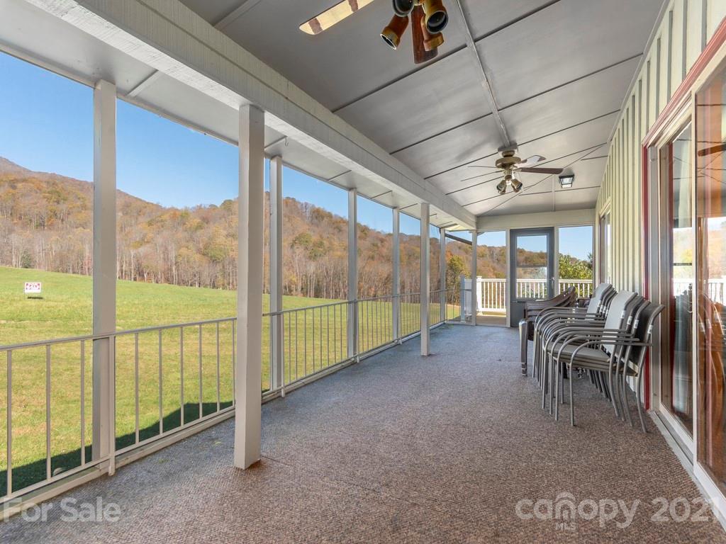 566 Walker Road Waynesville, NC 28786 - Photo 8 of 28 a view of a porch with furniture and floor to ceiling window