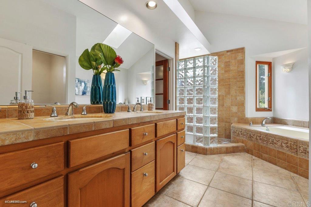 602 Sereno View Road Encinitas, CA 92024 - Photo 20 of 56 a spacious bathroom with a granite countertop sink a mirror and a bathtub