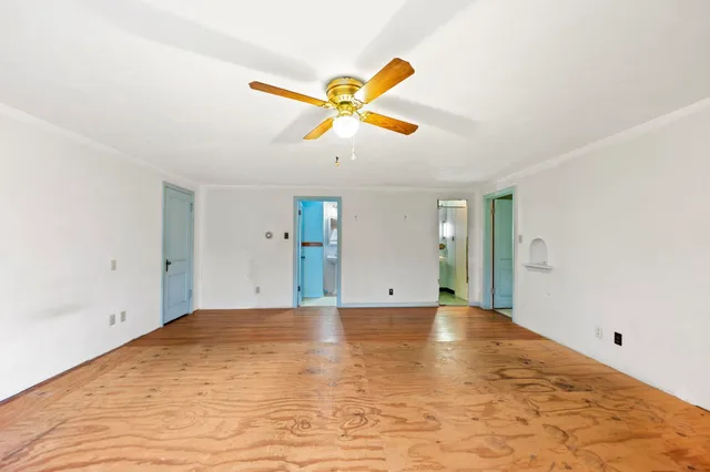 a view of a big room with wooden floor and windows
