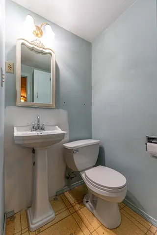 a bathroom with a toilet a sink and mirror