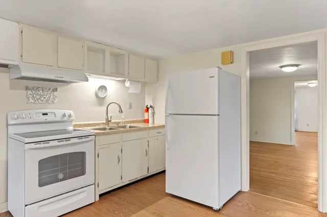 a kitchen with a refrigerator sink stove and cabinets