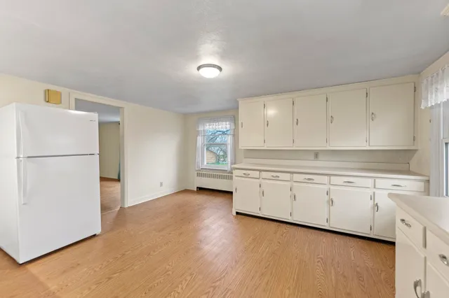 a kitchen with granite countertop white cabinets and refrigerator